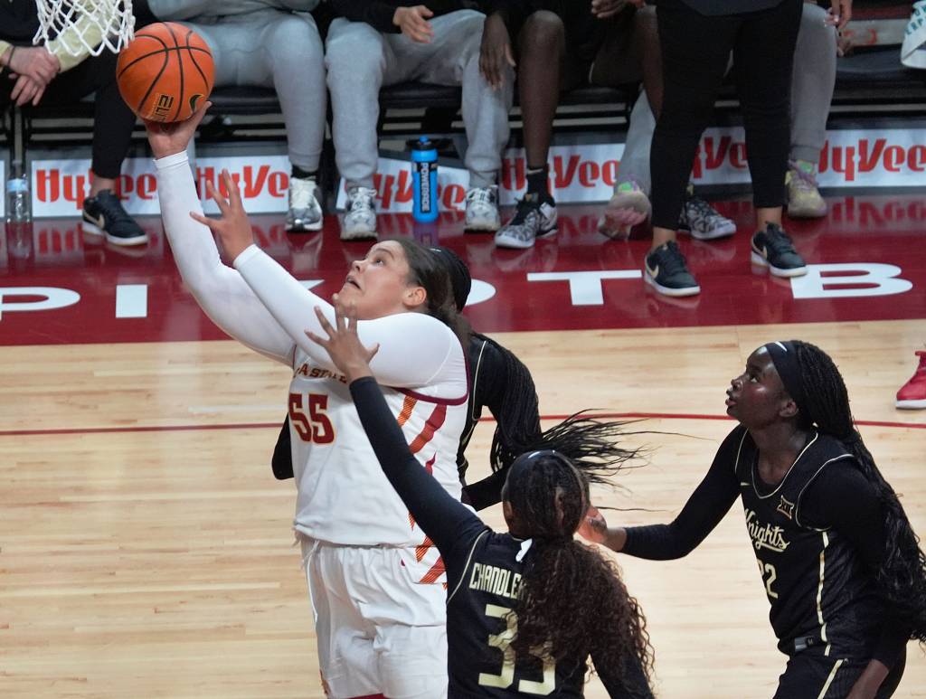 Iowa State center Audi Crooks shoots a right-handed layup. Two UCF forwards, positioned next to and behind her, can't contest the shot.