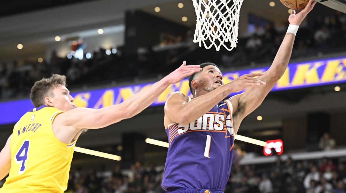 Phoenix Suns guard Devin Booker (1) shoots past Los Angeles Lakers guard Dalton Knecht (4) at Acrisure Arena.