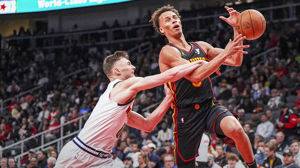 Atlanta Hawks guard Dyson Daniels (5) loses the ball to the defense of Denver Nuggets guard Christian Braun (0) during the second half at State Farm Arena. 