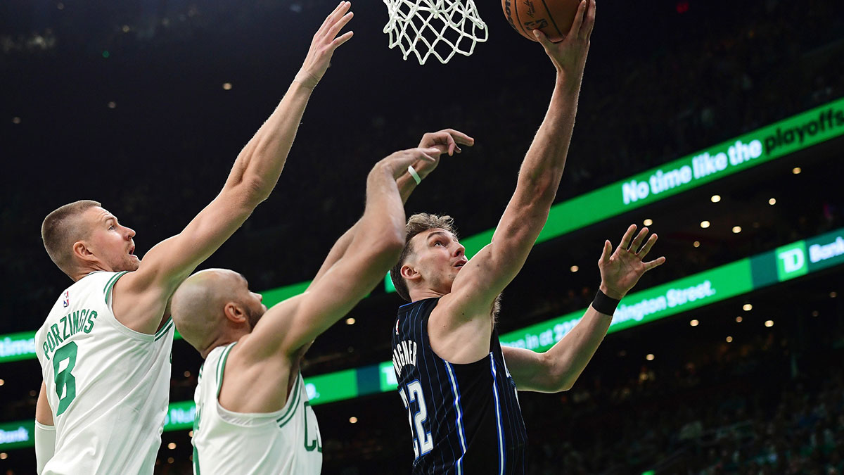 Orlando Magic forward Franz Wagner (22) drives to the basket past Boston Celtics center Kristaps Porzingis (8) and Boston Celtics guard Derrick White (9) during the first half at TD Garden.