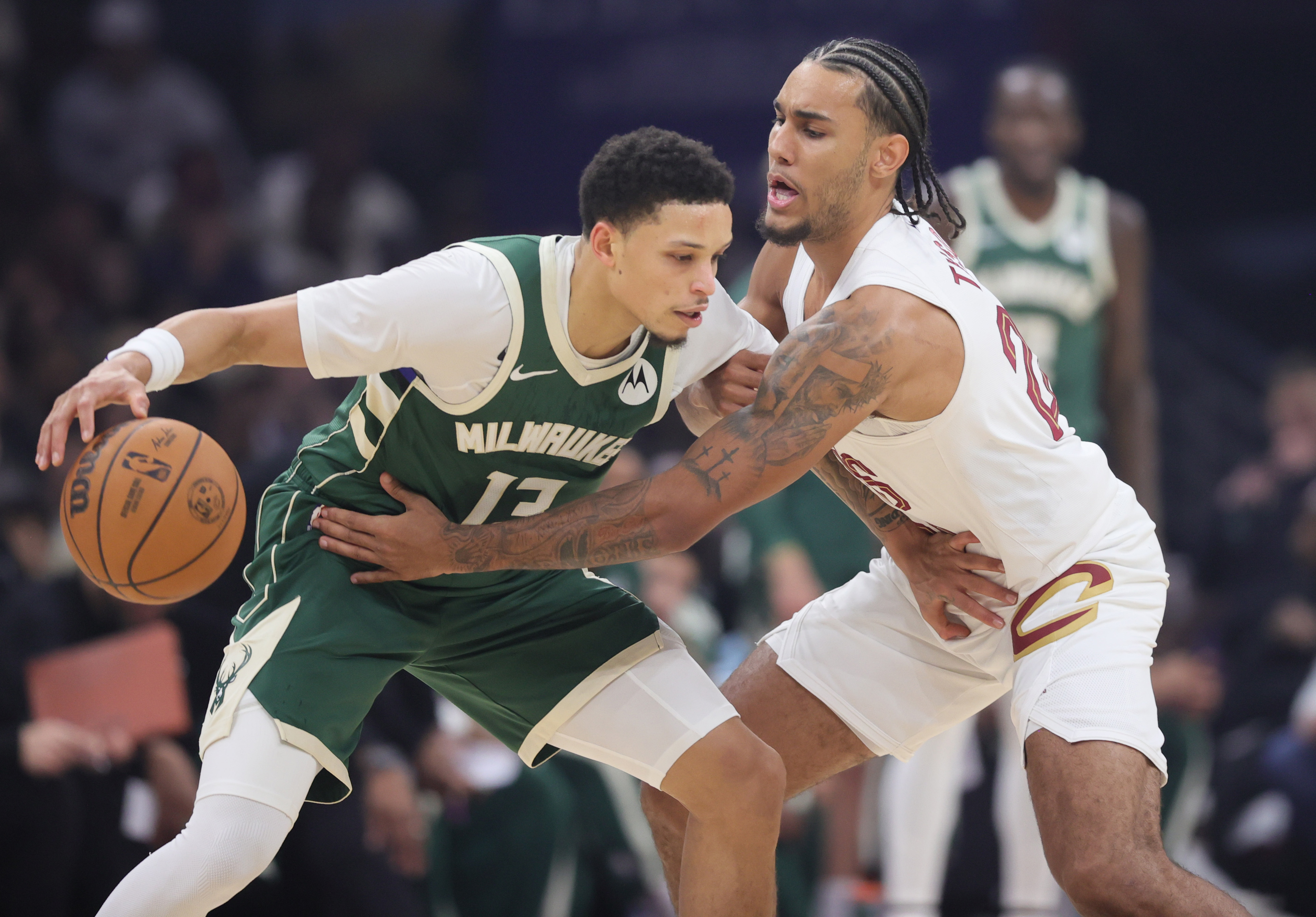 Cleveland Cavaliers guard Jaylon Tyson tries to knock the basketball loose from the dribble of Milwaukee Bucks guard Ryan Rollins in the first half at Rocket Arena. 