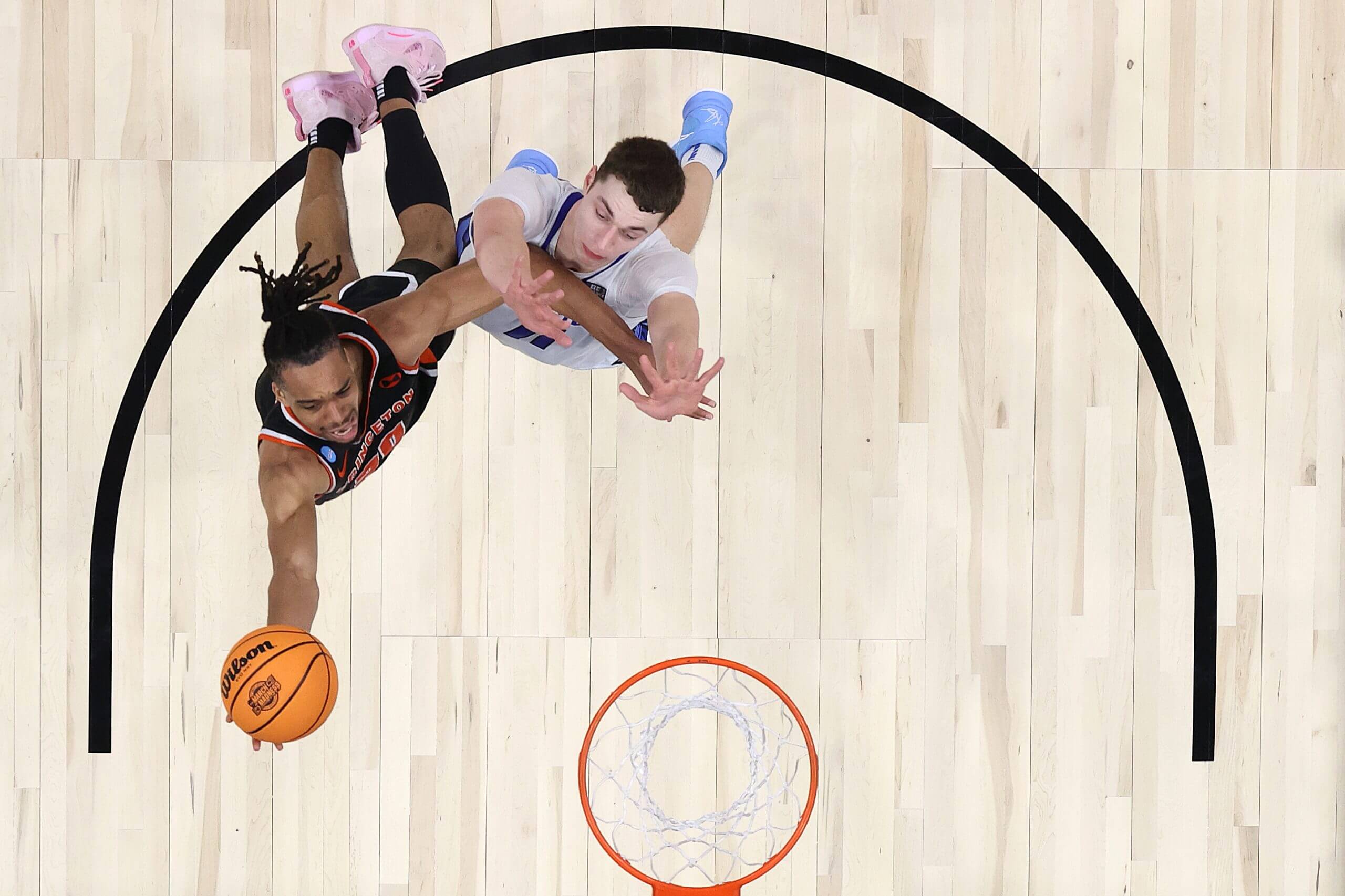 An image taken from above shows Evbuomwan attempting to score with the ball in his right hand during the Sweet 16 round of the 2023 NCAA men's basketball tournament