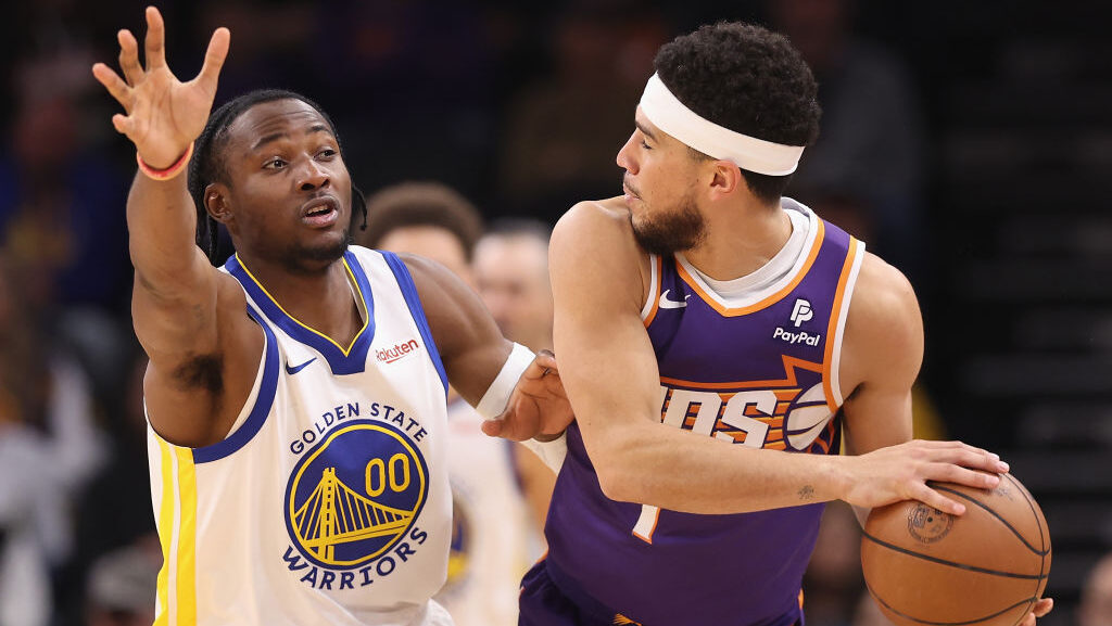 Jonathan Kuminga #00 of the Golden State Warriors defends against Devin Booker #1 of the Phoenix Su...