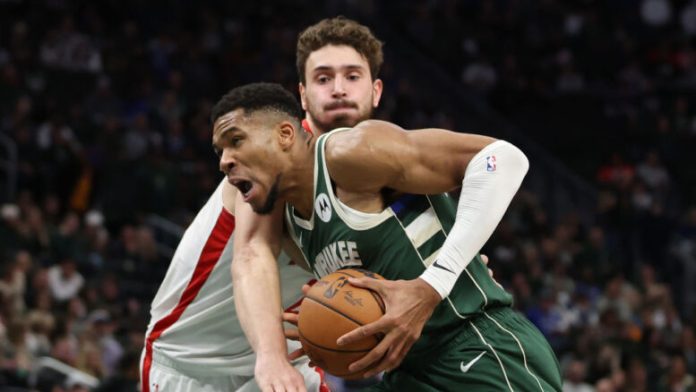 Milwaukee Bucks forward Giannis Antetokounmpo is guarded by Houston Rockets center Alperen Sengun
