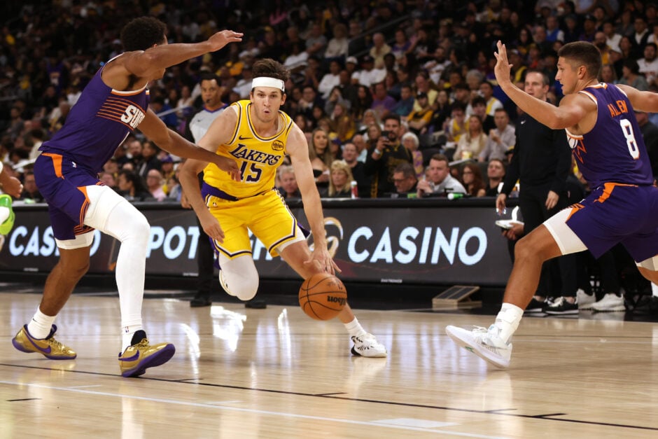 Austin Reaves #15 of the Los Angeles Lakers drives around Oso Ighodaro #11 of the Phoenix Suns during the second half of a game at Acrisure Arena on October 03, 2025 in Palm Springs, California.