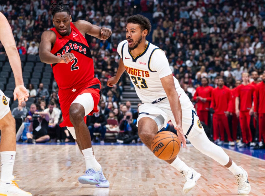 Cameron Johnson #23 of the Denver Nuggets drives past Jonathan Mogbo #2 of the Toronto Raptors during the first half in a preseason NBA game at Rogers Arena on October 6, 2025 in Vancouver, Canada.