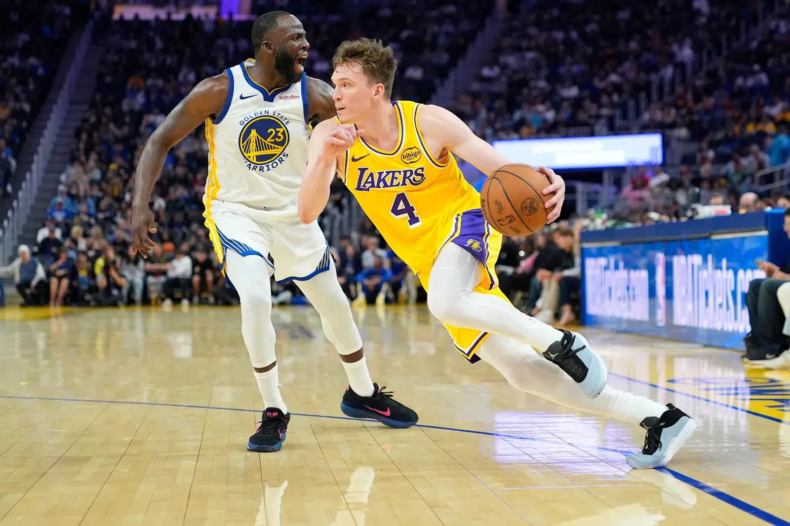 Dalton Knecht #4 of the Los Angeles Lakers drives towards the basket pas Draymond Green #23 of the Golden State Warriors