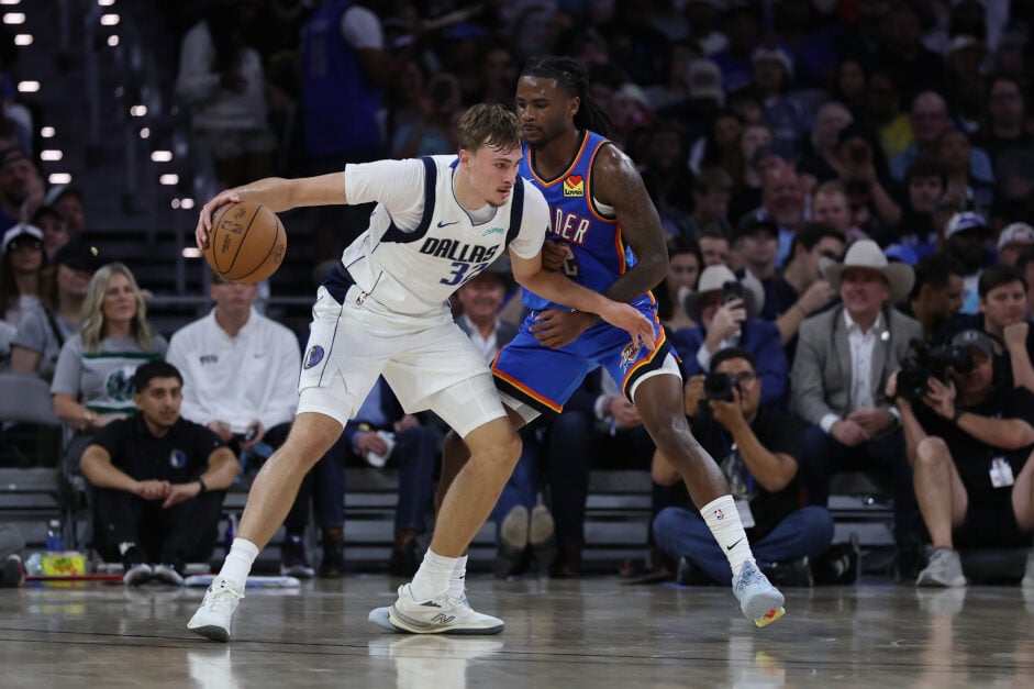 Cooper Flagg #32 of the Dallas Mavericks is defended by Cason Wallace #22 of the Oklahoma City Thunder during the first half of a preseason game at Dickies Arena.