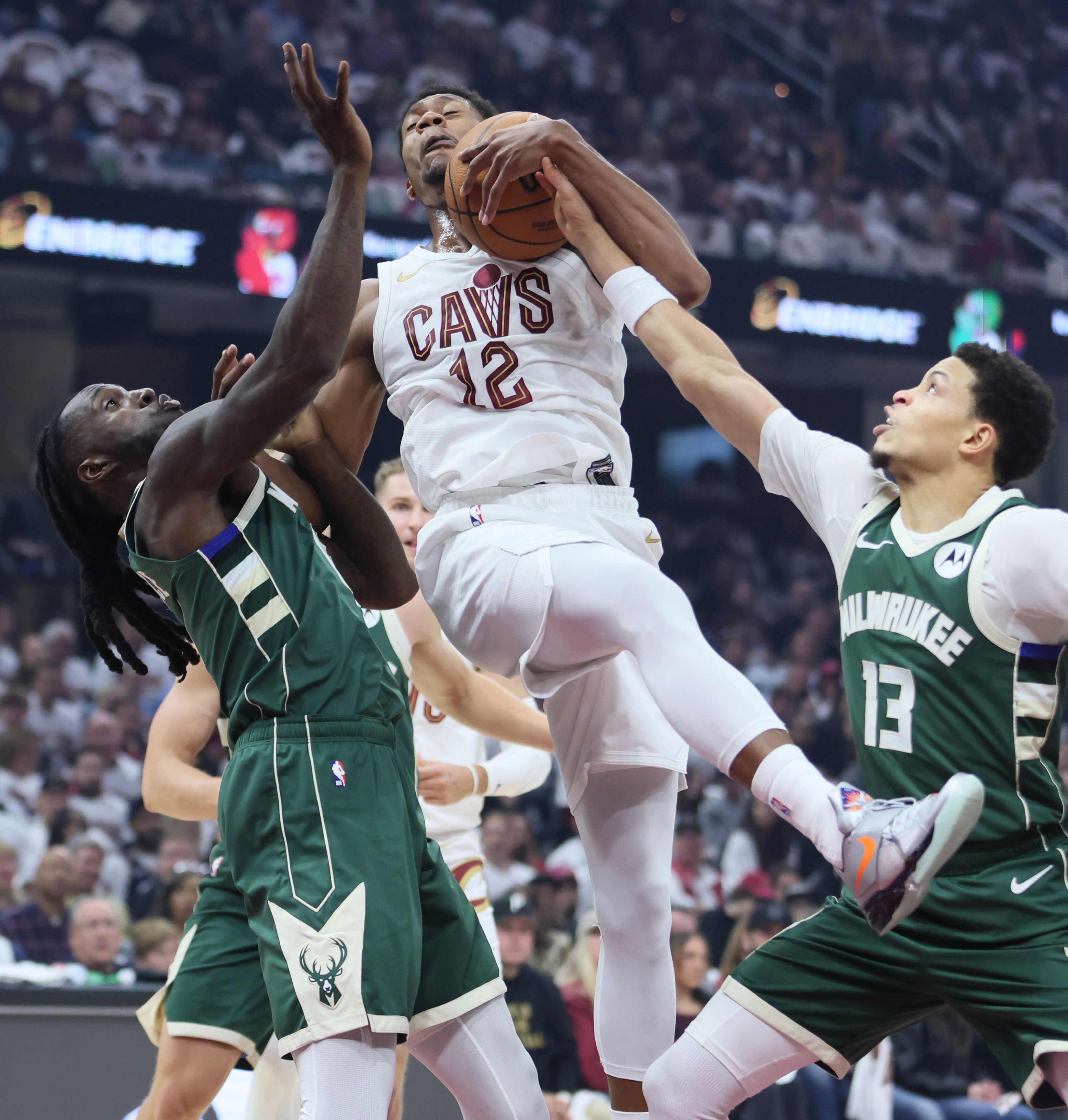 Cleveland Cavaliers forward De'Andre Hunter secures a rebound from Milwaukee Bucks forward Taurean Prince (L) and Milwaukee Bucks guard Ryan Rollins in the first half at Rocket Arena. 