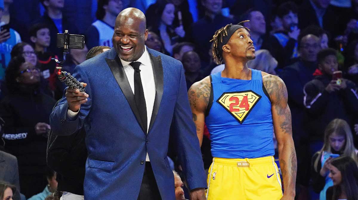 Shaquille O'Neal laughs while standing next to Los Angeles Lakers player Dwight Howard during the slam dunk contest during NBA All Star Saturday Night at United Center