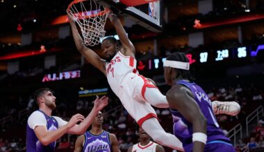 Houston Rockets forward Kevin Durant (7) hangs from the hoop after dunking during the first half of an NBA basketball preseason game against the Utah Jazz in Houston, Wednesday, Oct. 8, 2025. (AP Photo/Ashley Landis)