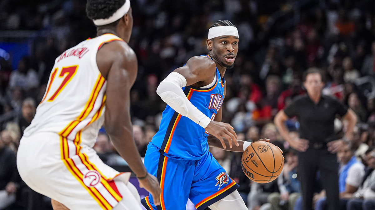 Oklahoma City Thunder guard Shai Gilgeous-Alexander (2) dribbles against Atlanta Hawks forward Onyeka Okongwu (17) during the second half at State Farm Arena.