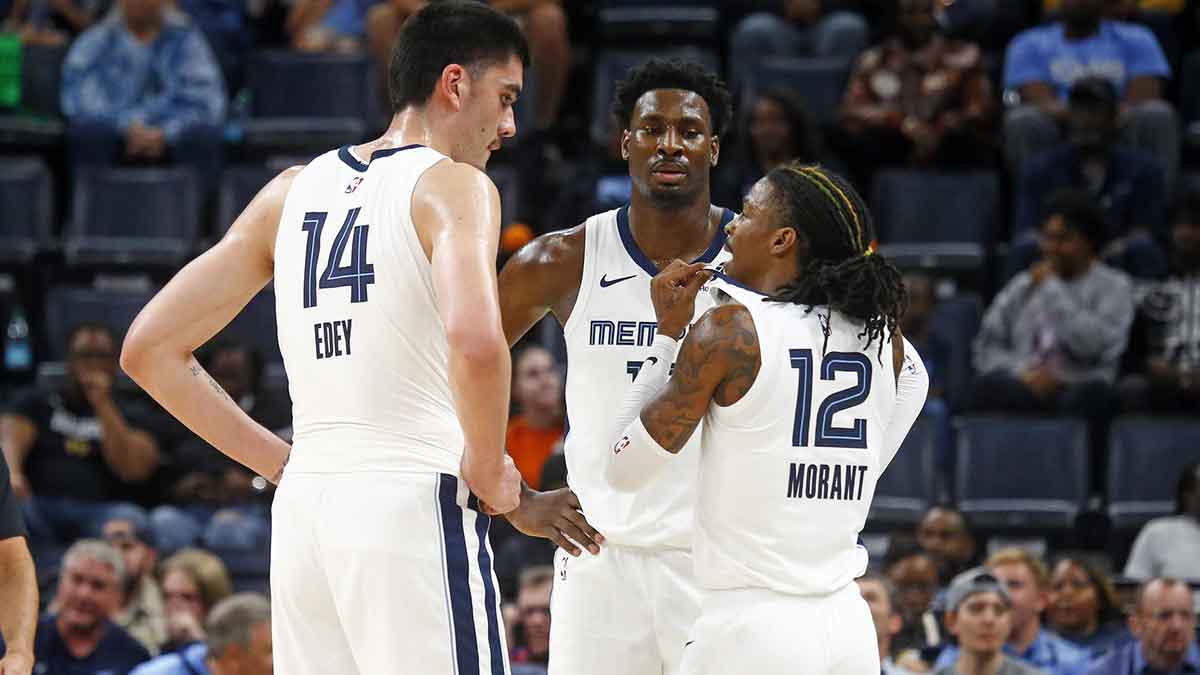 Memphis Grizzlies guard Ja Morant (12) talks with center Zach Edey (14) and forward Jaren Jackson Jr. (13) during the first half against the Brooklyn Nets at FedExForum.