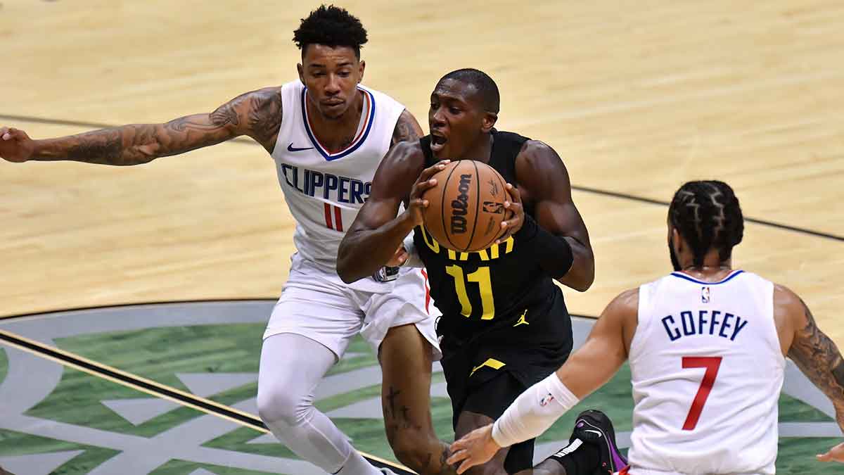 Utah Jazz guard Kris Dunn (11) drives to the basket between Los Angels Clippers guard Joshua Primo (11) and guard Amir Coffey (7) during the second half at SimpliFi Arena at Stan Sheriff Center.