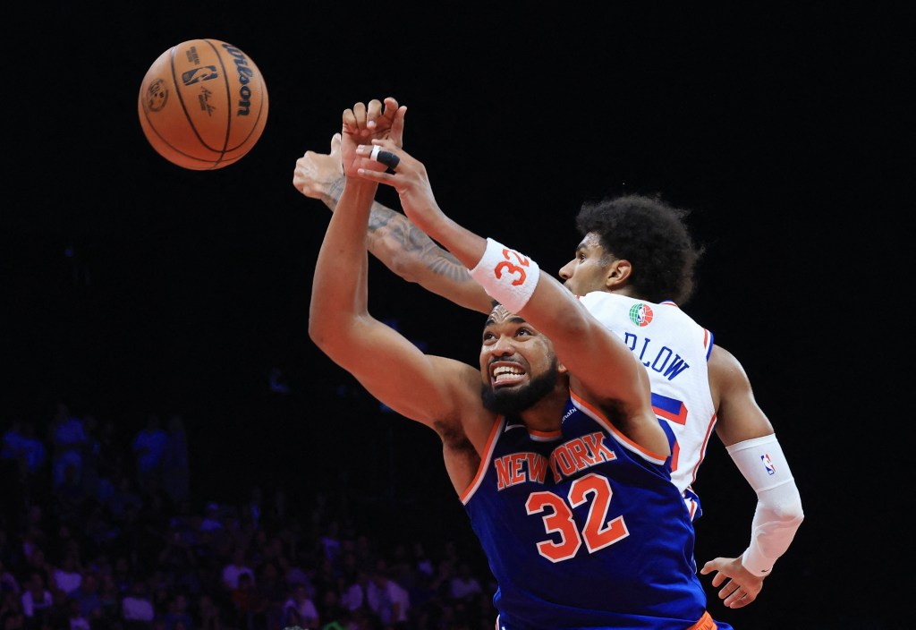 Karl-Anthony Towns battles Dominick Barlow for a rebound during the Knicks' preseason win over the 76ers on Oct. 4, 2025.