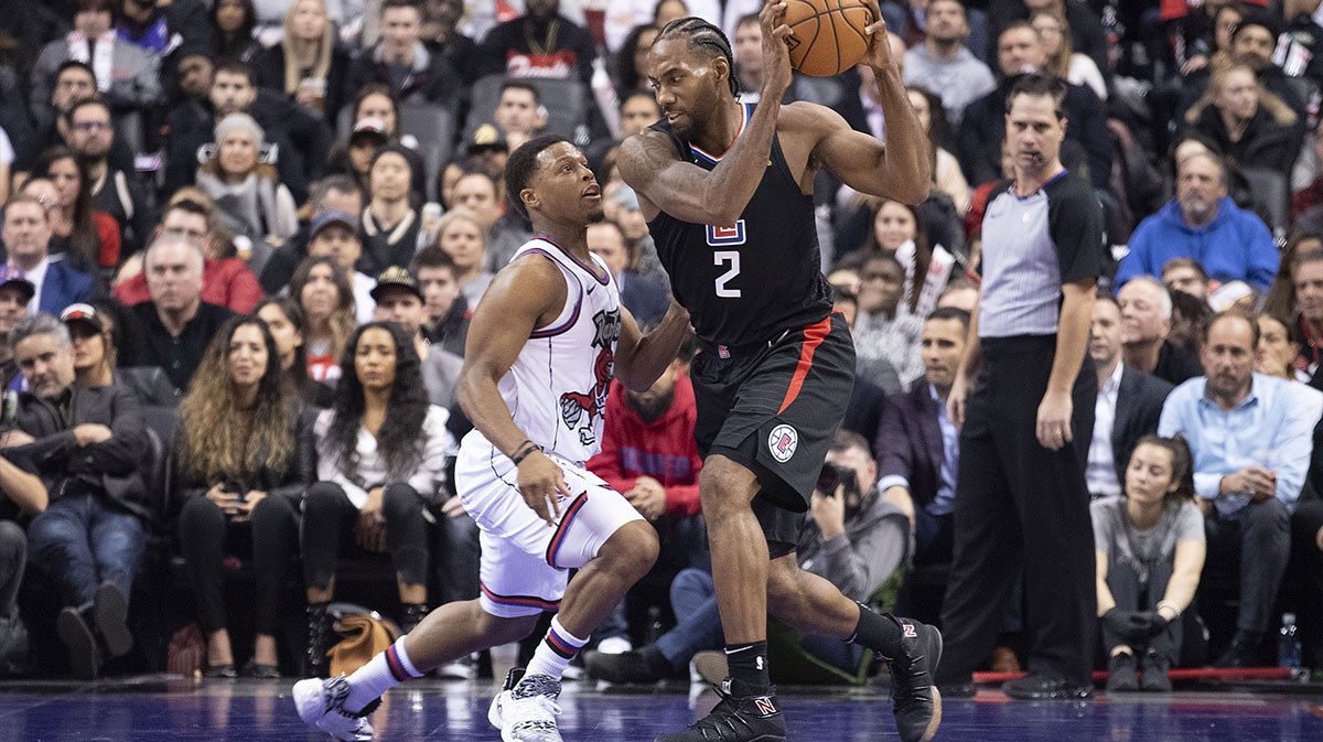 Clippers forward Kawhi Leonard (2) controls a ball as Toronto Raptors guard Kyle Lowry (7) tries to defend during the third quarter at Scotiabank Arena.
