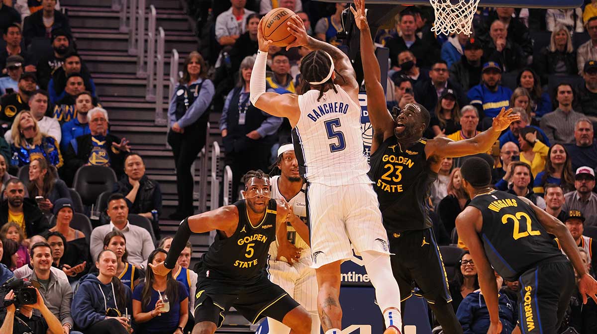 Orlando Magic forward Paolo Banchero (5) shoots the ball against Golden State Warriors forward Draymond Green (23) during the fourth quarter at Chase Center. 