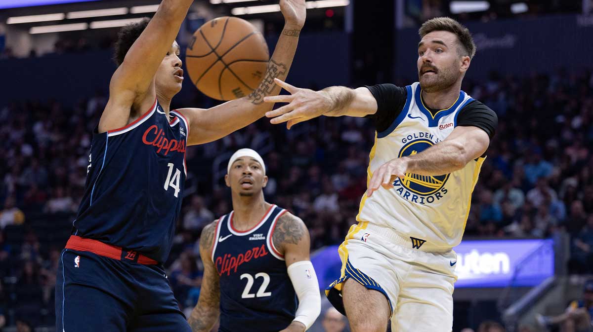 Golden State Warriors guard Pat Spencer (61) passes around Los Angeles Clippers center Yanic Konan Niederhäuser (14) during the first quarter at Chase Center.