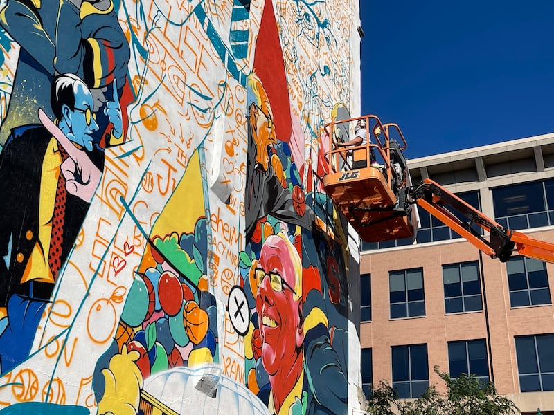 Chris B. Murray paints a mural of Jim Boeheim, longtime coach Syracuse University basketball team, in downtown Syracuse.