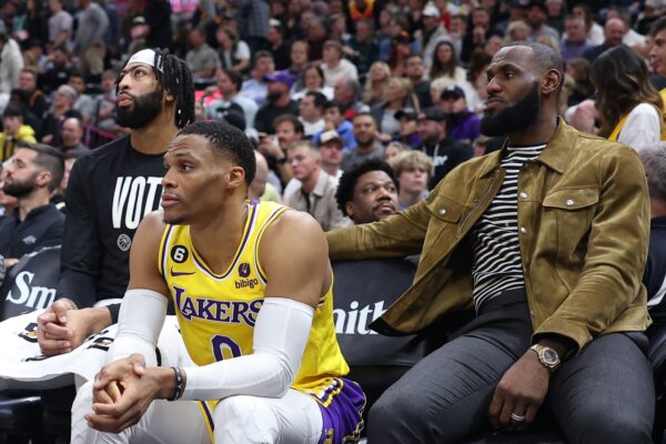Los Angeles Lakers forward Anthony Davis (left) and guard Russell Westbrook (center) along with forward LeBron James (right) watch their team from the bench against the Utah Jazz in the fourth quarter at Vivint Arena.