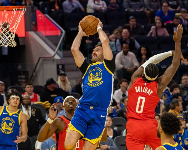 Golden State Warriors guard Pat Spencer shoots a layup while defended by the Houston Rockets' Aaron Holiday during their NBA game at Chase Center in San Francisco on April 6. (John Lee - Santa Cruz Sentinel file)