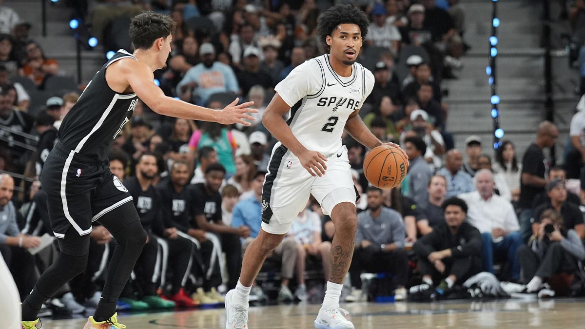Spurs guard Dylan Harper (2) dribbles against Brooklyn Nets guard Ben Saraf (77) in the first half at Frost Bank Center