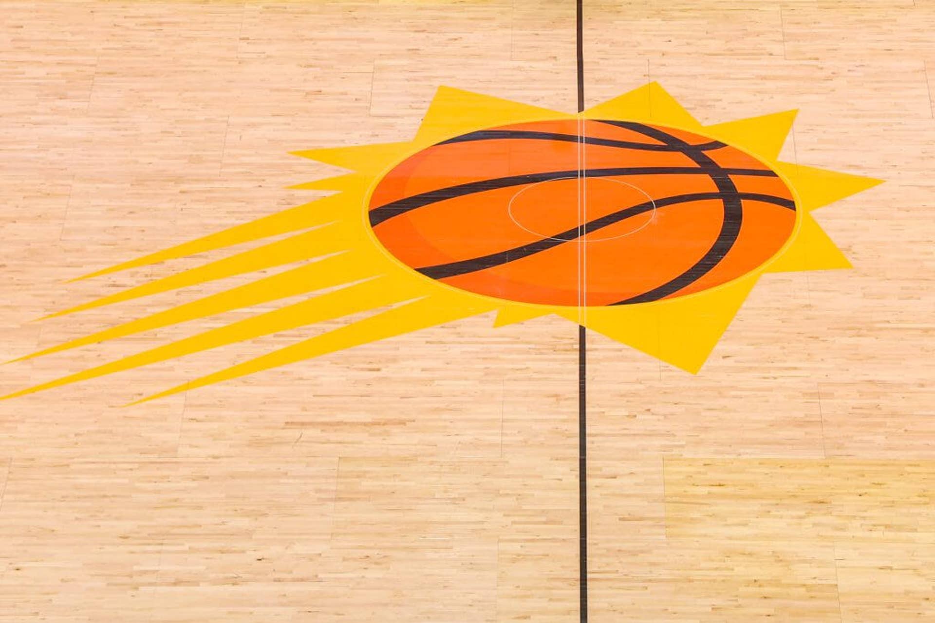 The Phoenix Suns logo on a basketball court.