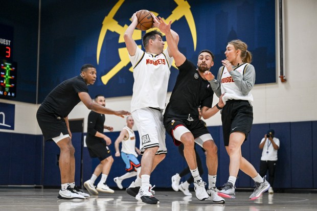 Media players Adam Mares and Katy Winge mix it up with player development coach Ben Potts during a scrimmage between the Denver Nuggets coaching staff and local media members at Ball Arena on Tuesday, Oct. 21, 2025. The coaches escaped the practice facility by way of a thrilling 114-16 win. (Photo by AAron Ontiveroz/The Denver Post)