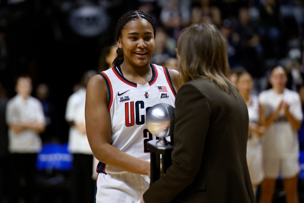 UConn forward Sarah Strong presented with the Big East Freshman of the Year trophy by Commissioner of the Big East Conference Val Ackerman before an NCAA college basketball game in the quarterfinals of the Big East Conference tournament, Saturday, March 8, 2025, in Uncasville, Conn. (AP Photo/Jessica Hill)