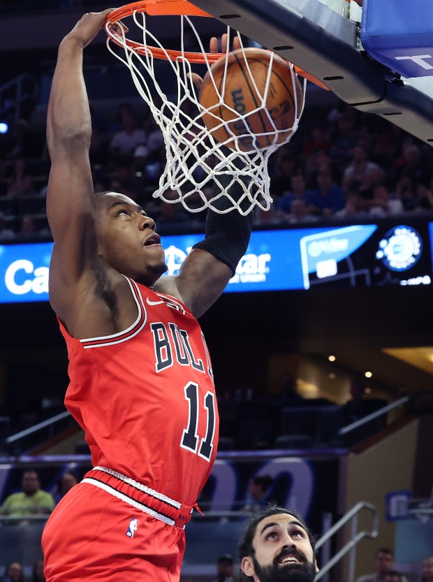 Chicago guard Ayo Dosunmu (11) slam dunks over Orlando center...