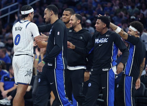 Orlando injured guard Jalen Suggs (middle) and others come off...