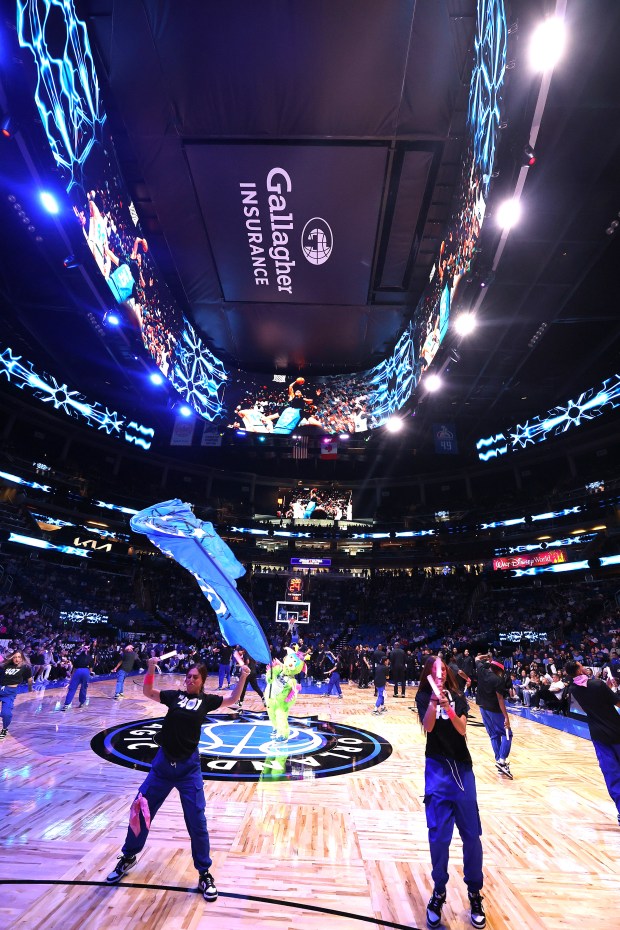 Dancers perform under a new gigantic big-screen television over the...
