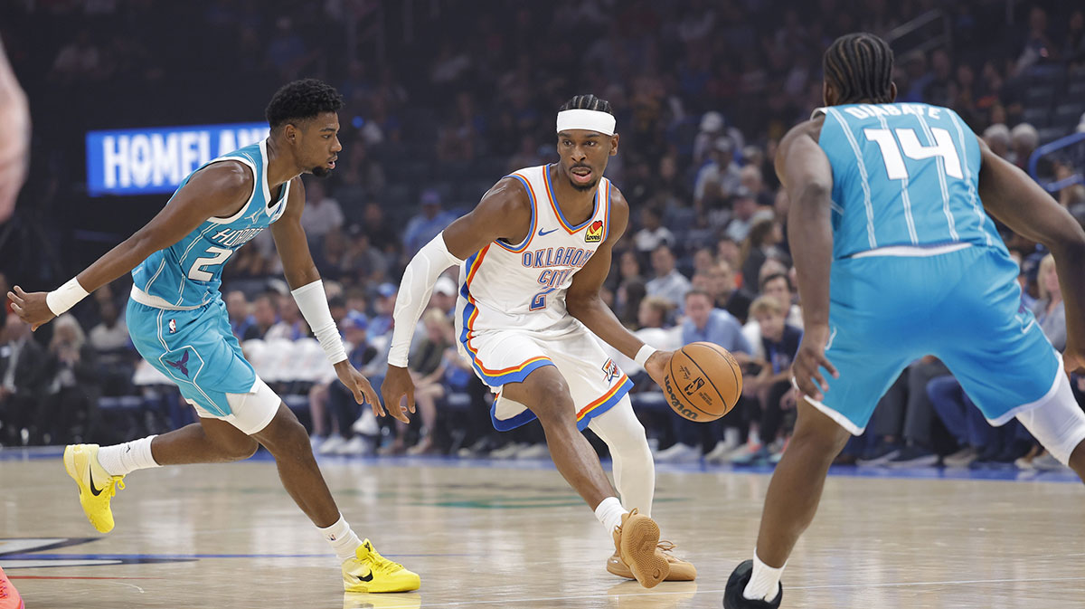 Thunder guard Shai Gilgeous-Alexander (2) drives between Charlotte Hornets forward Brandon Miller (24) and forward Moussa Diabaté (14) during the 1st quarter of a game between the Charlotte Hornets and the Oklahoma City Thunder at Paycom Center