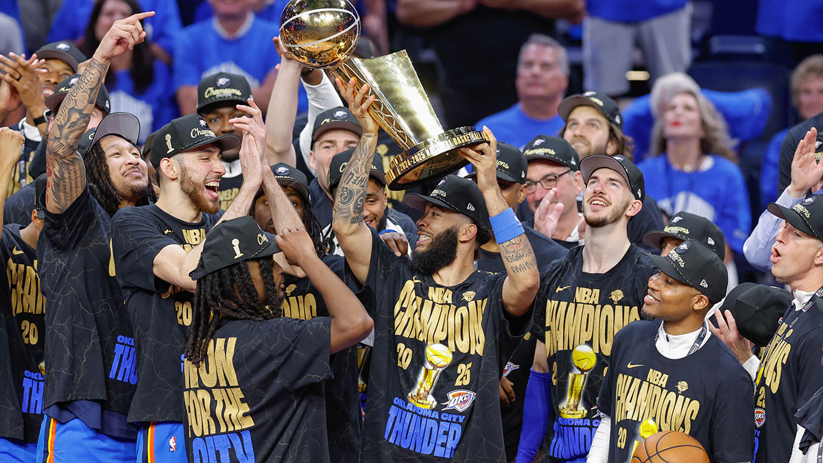 Oklahoma City Thunder forward Kenrich Williams (34) holds up the NBA Finals Larry O'Brien Championship Trophy after his team defeated the Indiana Pacers in game seven of the 2025 NBA Finals at Paycom Center. 