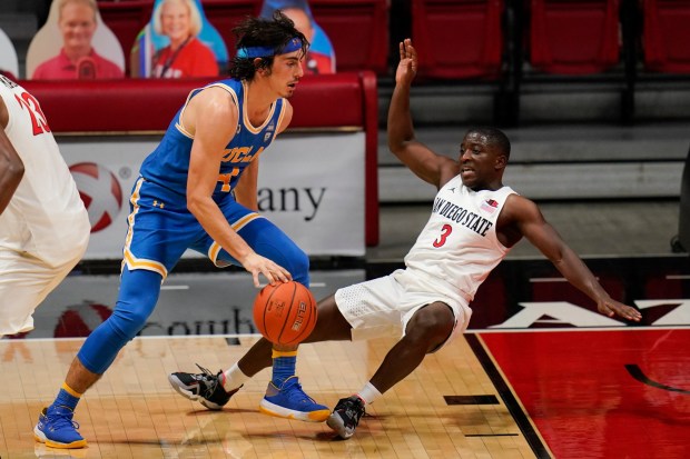 UCLA guard Jaime Jaquez Jr., left, is called for charging on San Diego State guard Terrell Gomez (3) during the first half of an NCAA college basketball game Wednesday, Nov. 25, 2020, in San Diego. (AP Photo/Gregory Bull)
