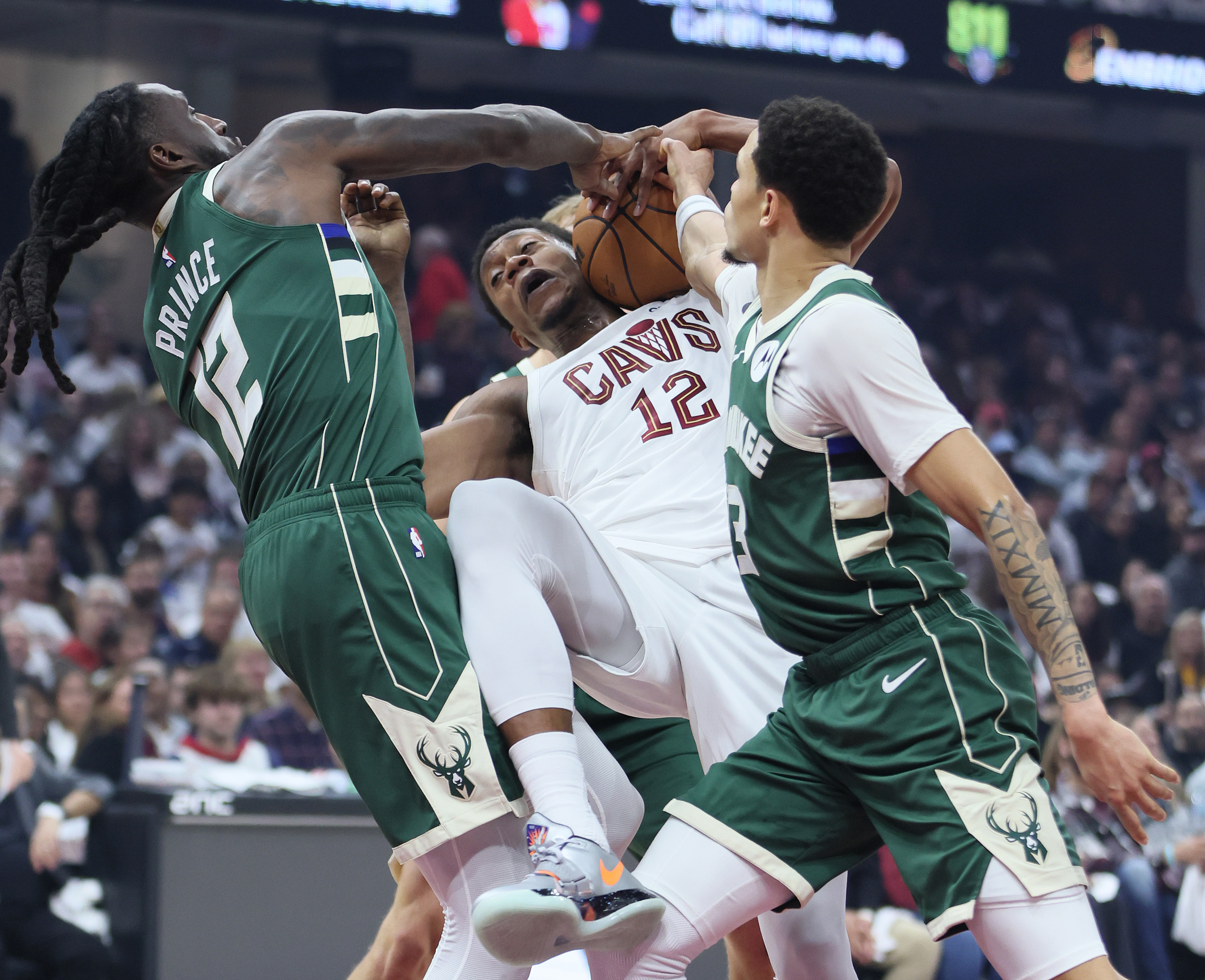 Cleveland Cavaliers forward De'Andre Hunter secures a rebound from Milwaukee Bucks forward Taurean Prince (L) and Milwaukee Bucks guard Ryan Rollins in the first half at Rocket Arena. 