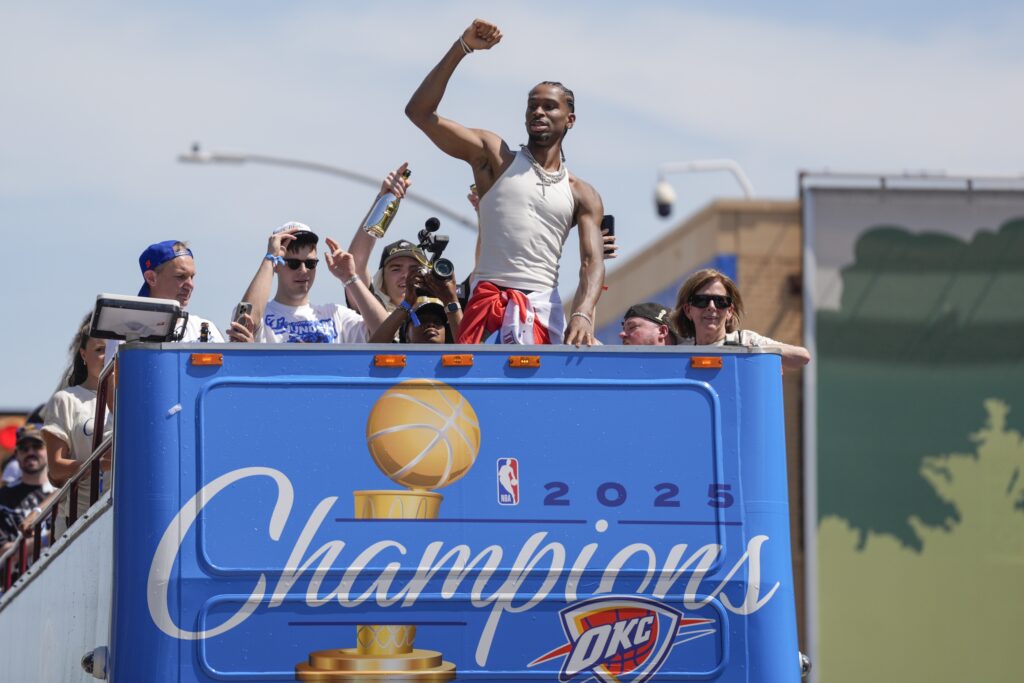 Oklahoma City Thunder guard Shai Gilgeous-Alexander gestures to the crowd as the Oklahoma City Thunder celebrate their first NBA Finals title win with a champions parade throughout downtown Oklahoma City on Tuesday, June 24, 2025. He will feature heavily in one of two OKC Thunder documentaries premiering this week