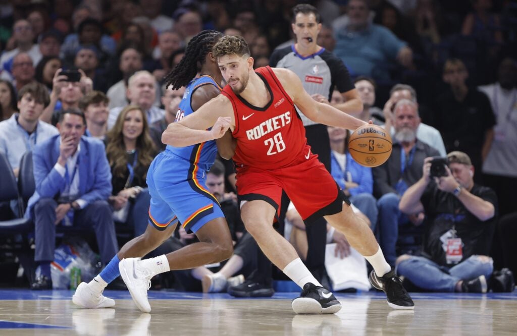 Oct 21, 2025; Oklahoma City, Oklahoma, USA; Houston Rockets center Alperen Sengun (28) drives past Oklahoma City Thunder guard Cason Wallace (22) during the first half at Paycom Center. Mandatory Credit: Alonzo Adams-Imagn Images