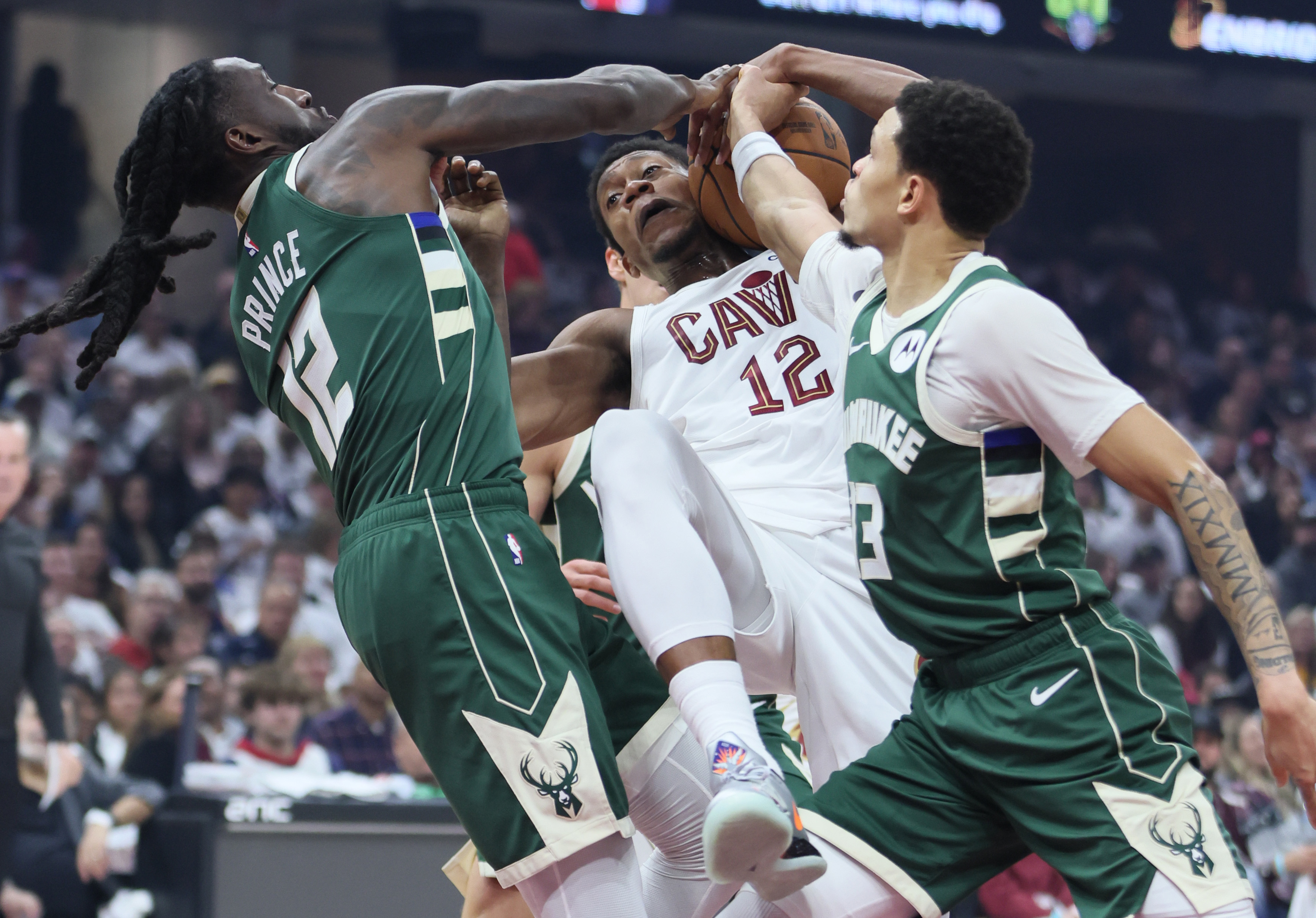 Cleveland Cavaliers forward De'Andre Hunter secures a rebound from Milwaukee Bucks forward Taurean Prince (L) and Milwaukee Bucks guard Ryan Rollins in the first half at Rocket Arena. 
