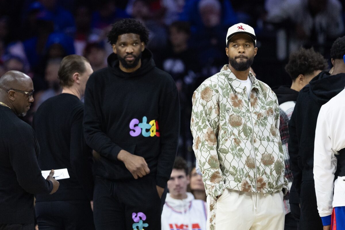 Injured Philadelphia 76ers Paul George (R) and Joel Embiid (L) look on during the first quarter against the Memphis Grizzlies at Wells Fargo Center.