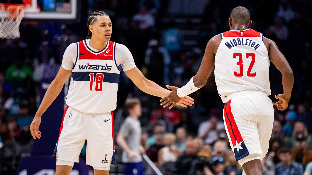 Washington Wizards forward Kyshawn George (18) celebrates with forward Khris Middleton (32) during the third quarter against the Charlotte Hornets at Spectrum Center.