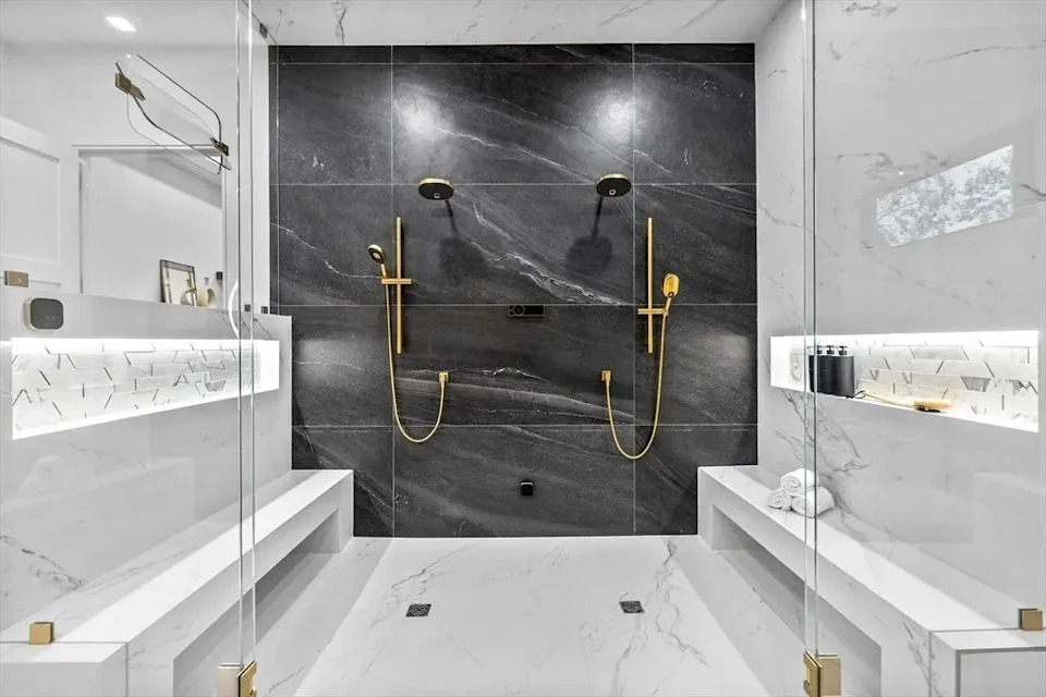 Shower with gold and marble in a luxury home in Massachusetts that belongs to Jrue Holiday