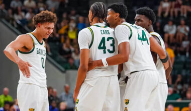 Baylor men's basketball players huddle on the court.