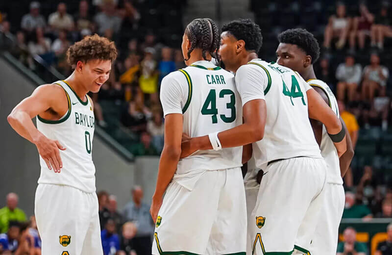 Baylor men's basketball players huddle on the court.
