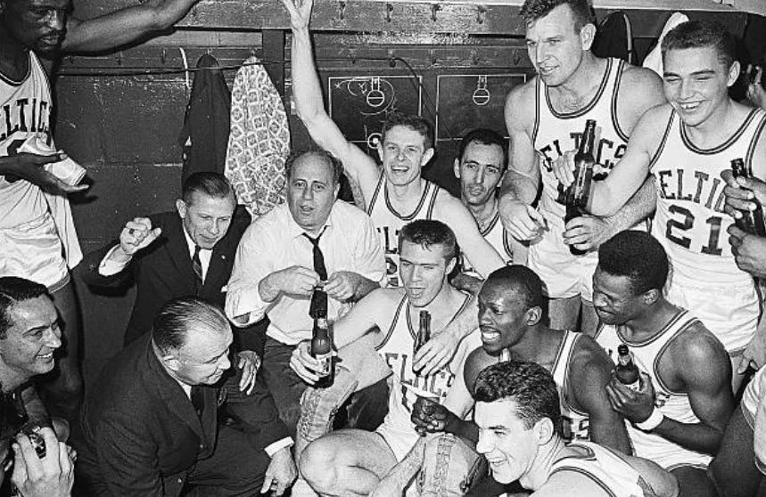 (Original Caption) 4/18/62 -BOSTON,MA.- : HAPPY CHAMPS...The victorious Boston Celtics, NBA basketball champions for the fourth consecutive year, whoop it up in the dressing room, flanking their coach Red Auerbach {white shirt} Gov. John Volpe of Mass., {rear,L} and Celtics owner Walter Brown {front,L}. The Celtics defeated the Los Angeles Lakers, 110-107, Boston Garden{4/18}.