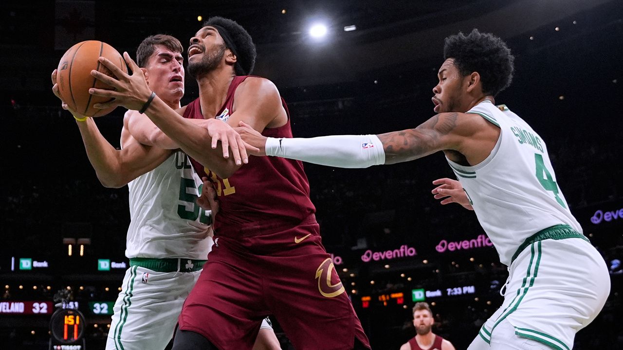Cleveland Cavaliers center Jarrett Allen, center, tries to drive to the basket against Boston Celtics center Luka Garza (52) and guard Anfernee Simons (4) during the first half of an NBA basketball game, Wednesday, Oct. 29, 2025, in Boston. (AP Photo/Charles Krupa)