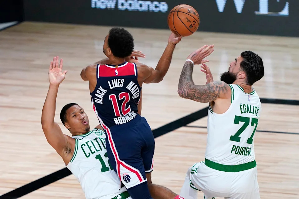 Aug 13, 2020; Lake Buena Vista, Florida, USA; Washington Wizards' Jerome Robinson, center, heads to the basket as Boston Celtics' Grant Williams, left, and Vincent Poirier (77) defend during the second half of an NBA basketball game Thursday, Aug. 13, 2020 in Lake Buena Vista, Fla. at ESPN Wide World of Sports Complex. Mandatory Credit: Ashley Landis/Pool Photo-USA TODAY Sports