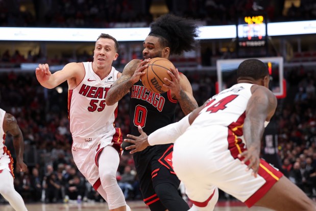Heat forwards Duncan Robinson (55) and Haywood Highsmith defend Bulls guard Coby White during the play-in tournament April 16, 2025, at the United Center. (Armando L. Sanchez/Chicago Tribune)