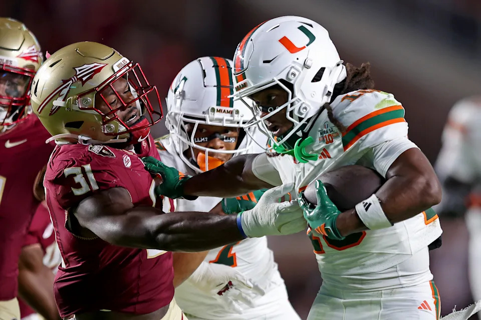 TALLAHASSEE, FLORIDA - OCTOBER 4: Malachi Toney #10 of the Miami Hurricanes stiff arms Elijah Herring #31 of the Florida State Seminoles to rush for extra yargdage in the game at Doak S. Campbell Stadium on October 4, 2025 in Tallahassee, Florida.  (Photo by Jason Clark/Getty Images)