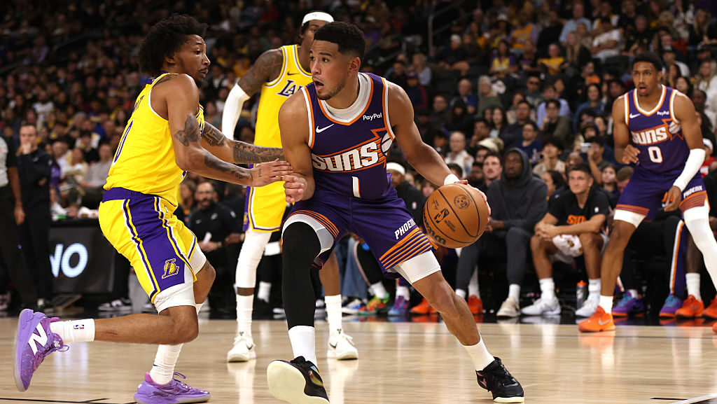 Devin Booker #1 of the Phoenix Suns drives around a Los Angeles Lakers defender during the second h...